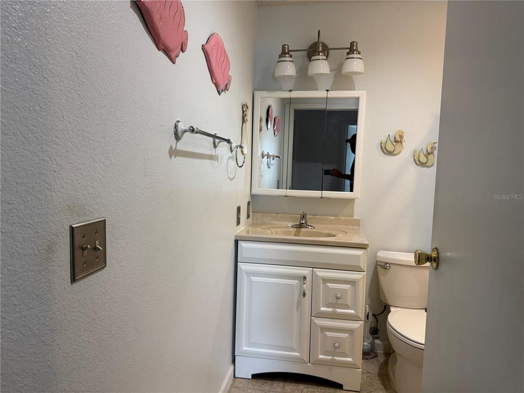 1605 Cherry Hill Road Lady Lake, FL 32159 - Photo 10 of 14 a bathroom with a toilet sink and mirror