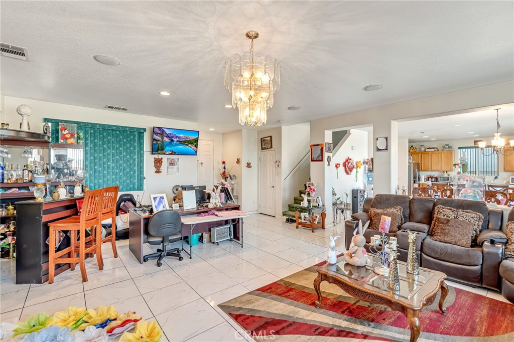 11036 Windcrest Court Adelanto, CA 92301 - Photo 14 of 45 a living room with furniture a rug and a chandelier