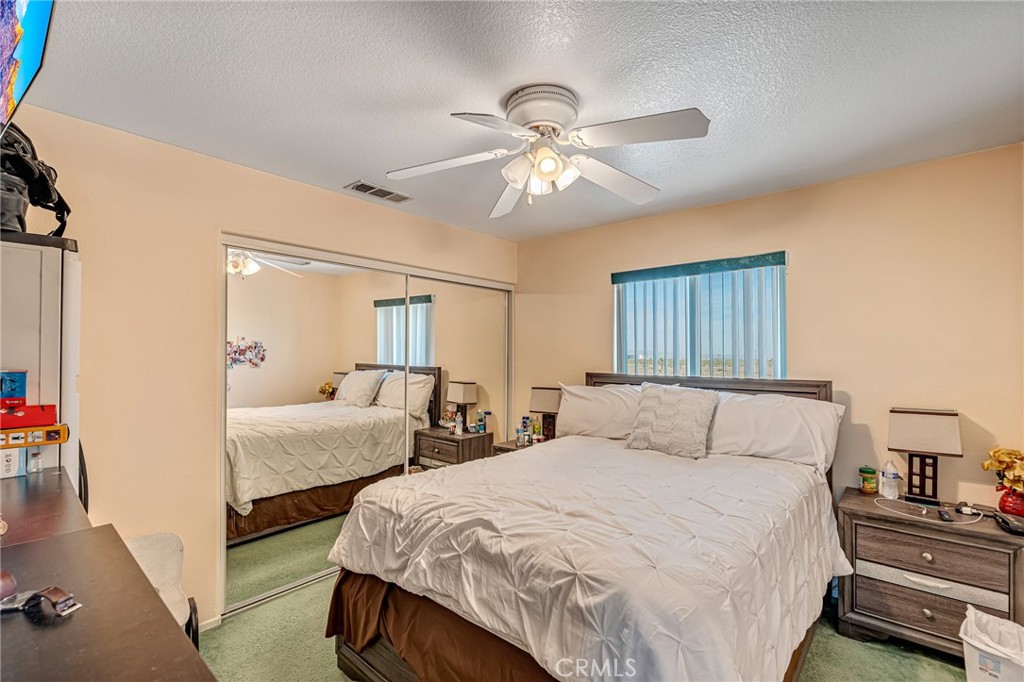 11036 Windcrest Court Adelanto, CA 92301 - Photo 15 of 45 a bedroom with two beds and a chandelier