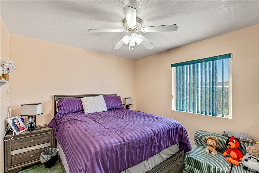 11036 Windcrest Court Adelanto, CA 92301 - Photo 16 of 45 a bedroom with a bed and a chandelier