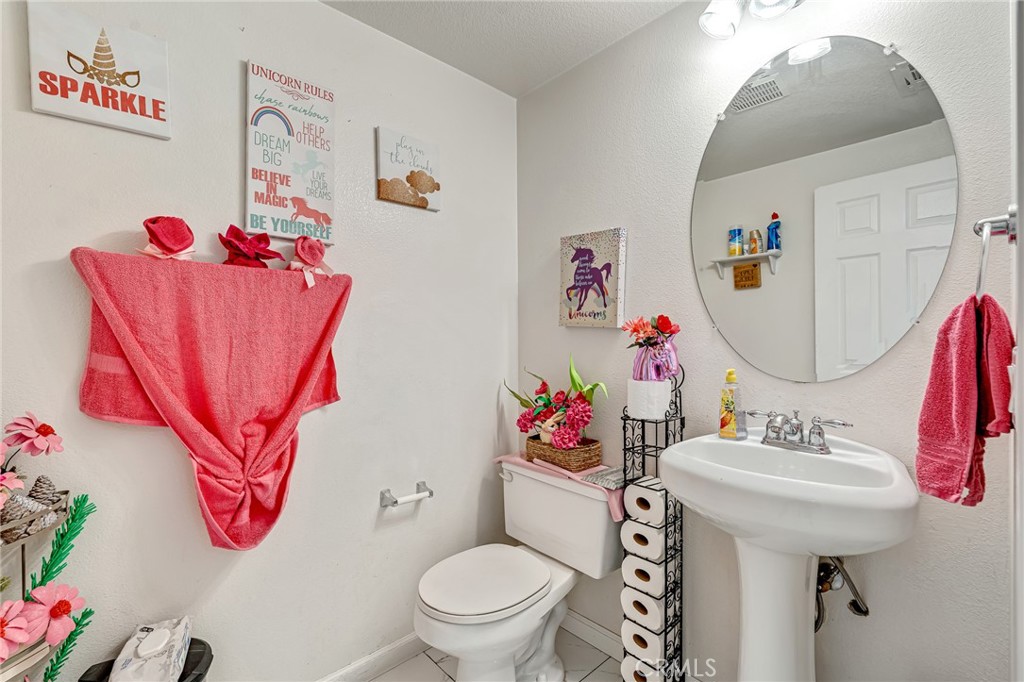 11036 Windcrest Court Adelanto, CA 92301 - Photo 18 of 45 a bathroom with a sink mirror and toilet