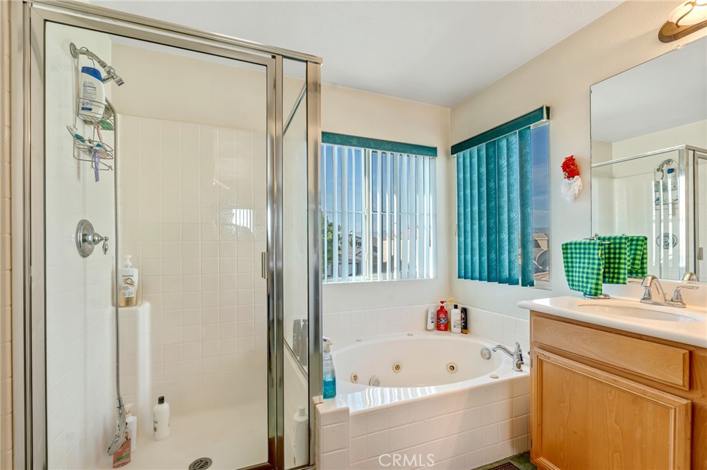 11036 Windcrest Court Adelanto, CA 92301 - Photo 22 of 45 a bathroom with a tub a sink and a large window