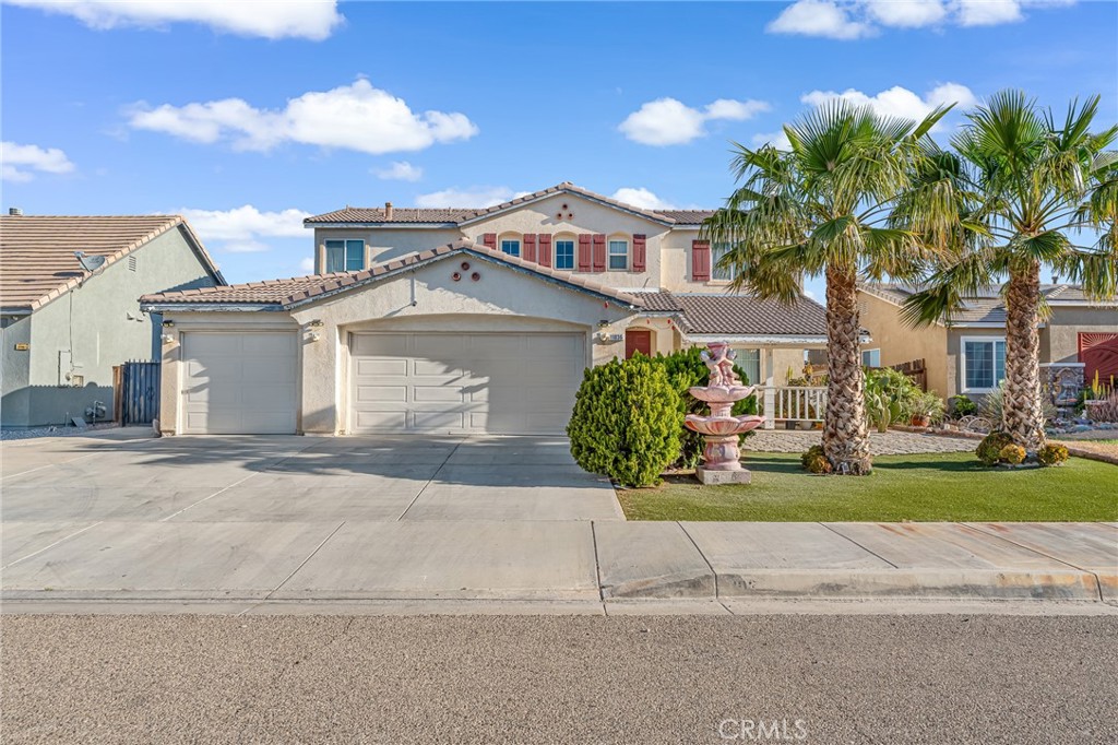 11036 Windcrest Court Adelanto, CA 92301 - Photo 26 of 45 a front view of a house with a yard and a garage