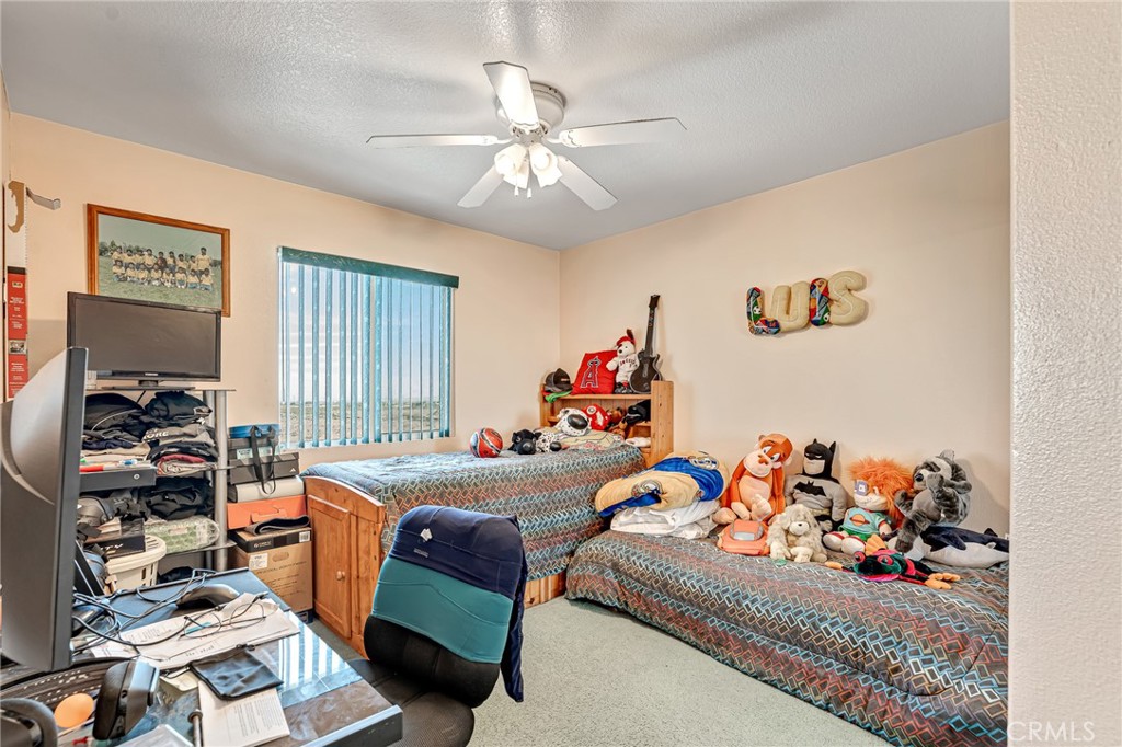 11036 Windcrest Court Adelanto, CA 92301 - Photo 32 of 45 a bed room with a bed and a couch