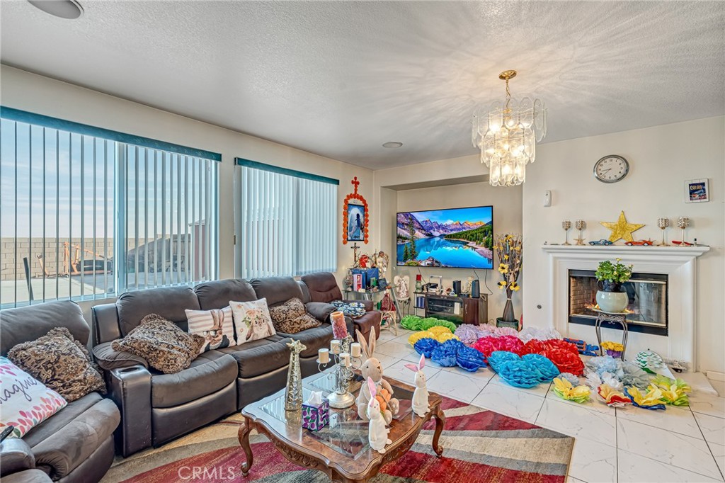 11036 Windcrest Court Adelanto, CA 92301 - Photo 6 of 45 a living room with furniture and a chandelier