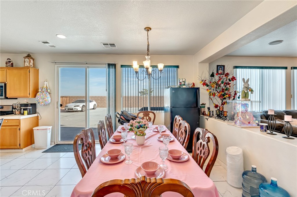 11036 Windcrest Court Adelanto, CA 92301 - Photo 7 of 45 a dining room with furniture a chandelier and window