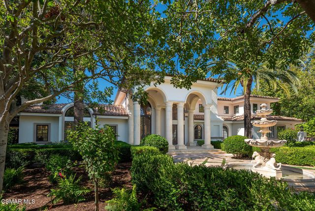 a front view of a residential houses with yard and green space