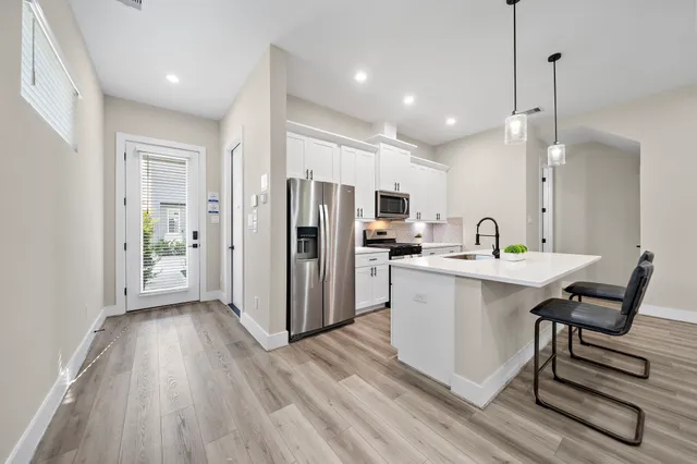 a kitchen with refrigerator cabinets and wooden floor