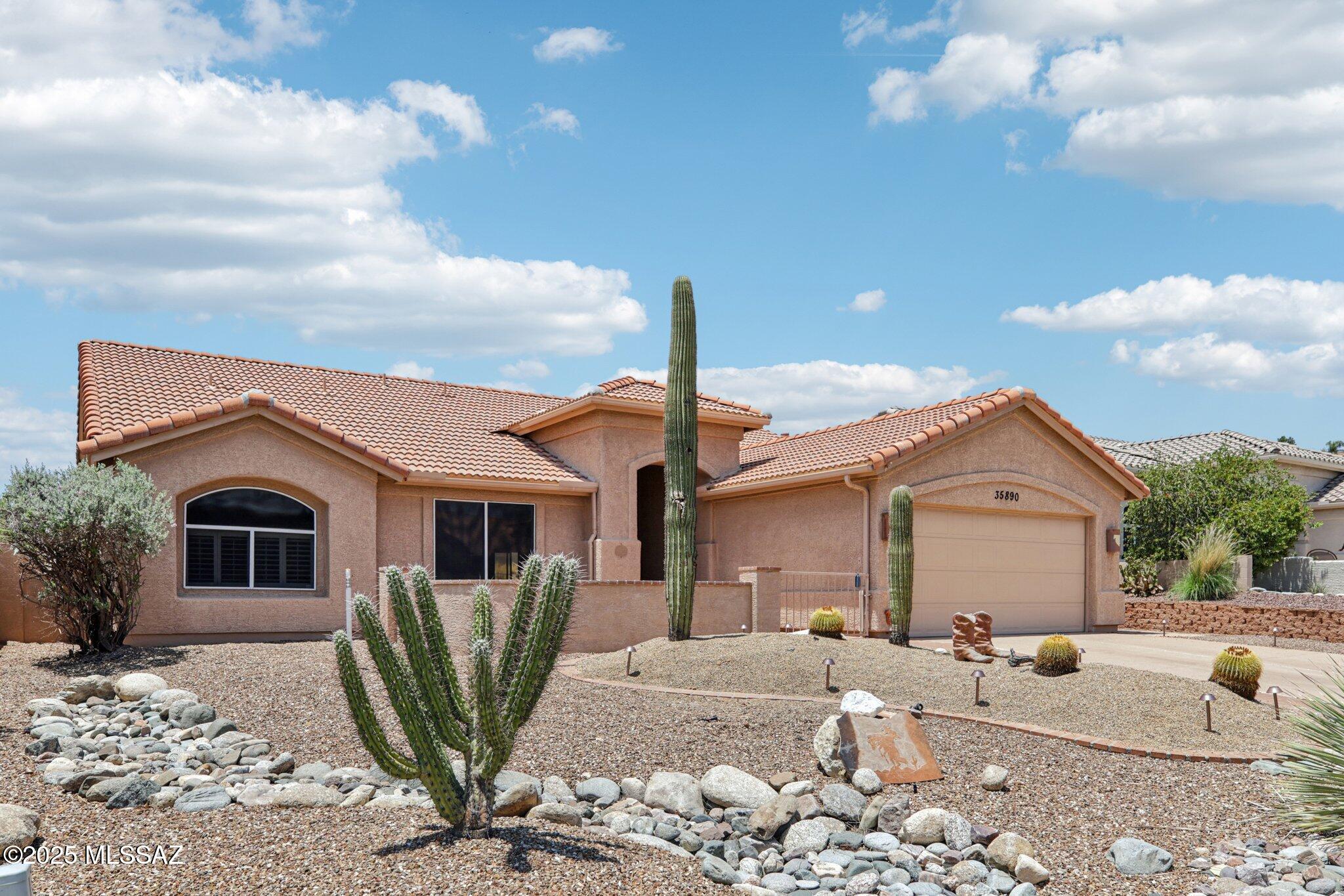 35890 Mesa Ridge Drive Tucson, AZ 85739 - Photo 1 of 31 a front view of a house with garden