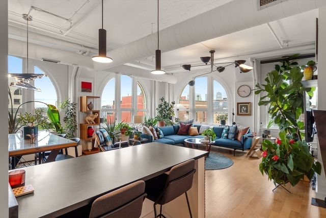 a kitchen with stainless steel appliances a sink dishwasher stove top oven and cabinets with wooden floor