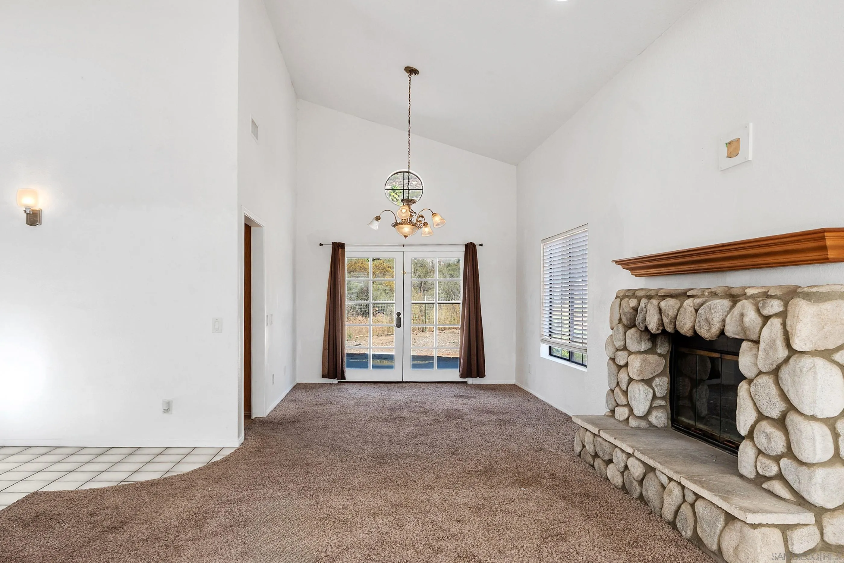 24252 Sargeant Road Ramona, CA 92065 - Photo 18 of 57 a view of an empty room with a fireplace and a window