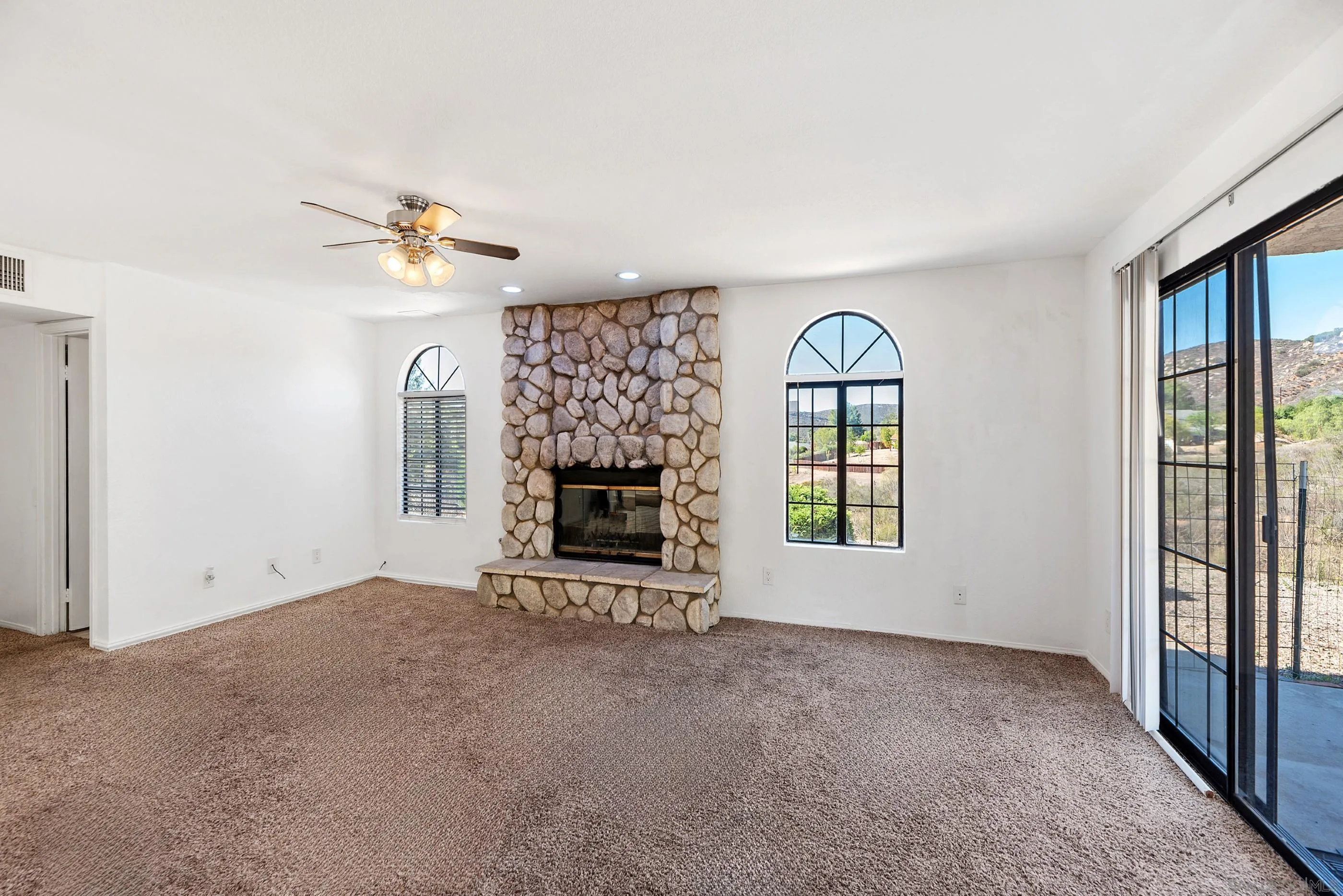 24252 Sargeant Road Ramona, CA 92065 - Photo 23 of 57 an empty room with windows and fireplace