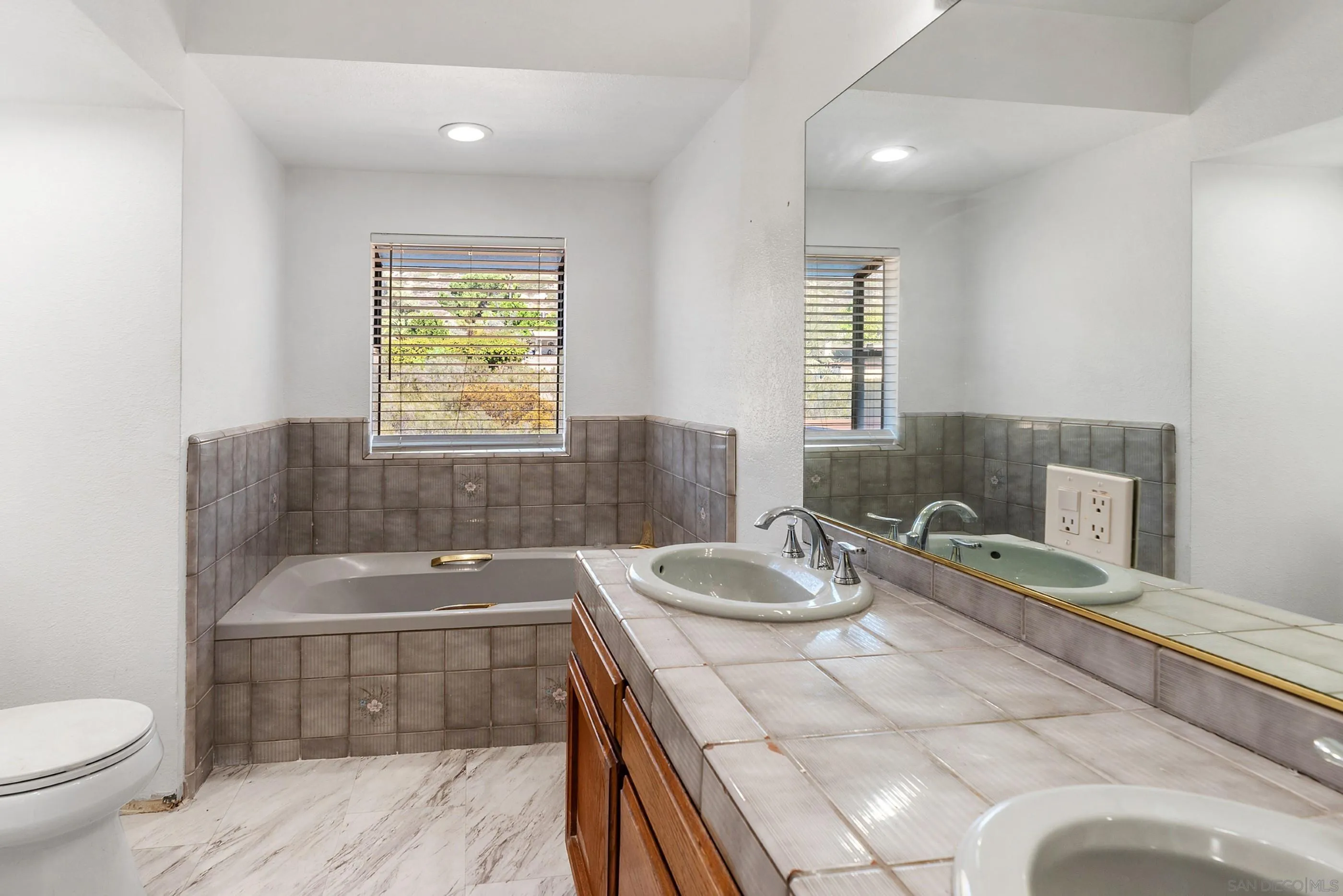 24252 Sargeant Road Ramona, CA 92065 - Photo 36 of 57 a bathroom with a granite countertop sink a toilet and bathtub