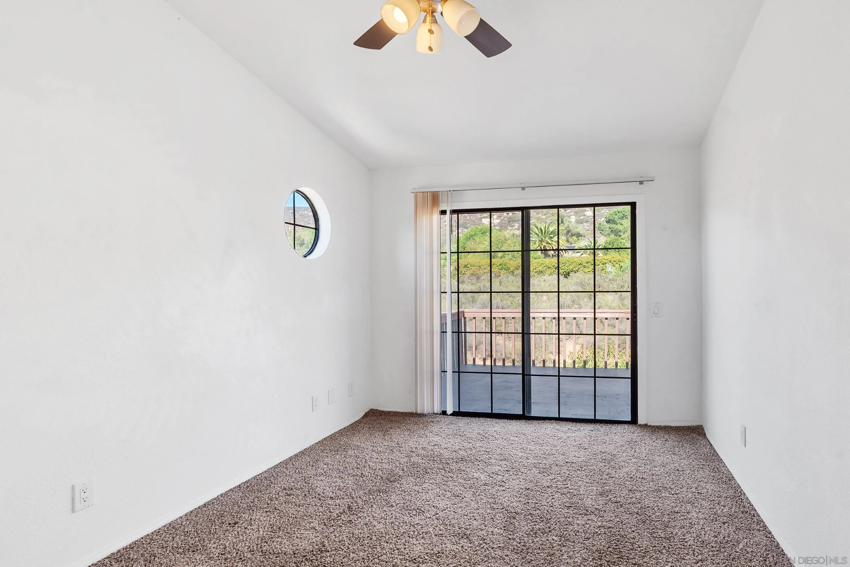 24252 Sargeant Road Ramona, CA 92065 - Photo 38 of 57 an empty room with chandelier fan and windows