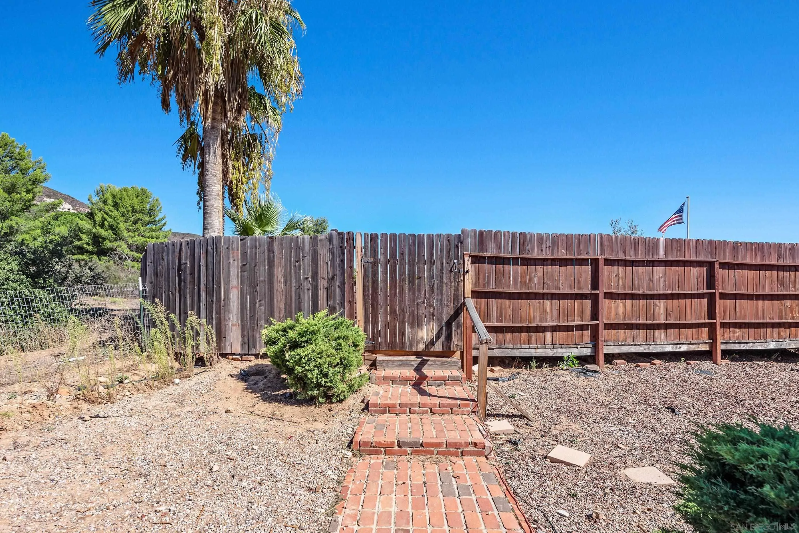 24252 Sargeant Road Ramona, CA 92065 - Photo 54 of 57 a view of backyard with wooden fence and a bench