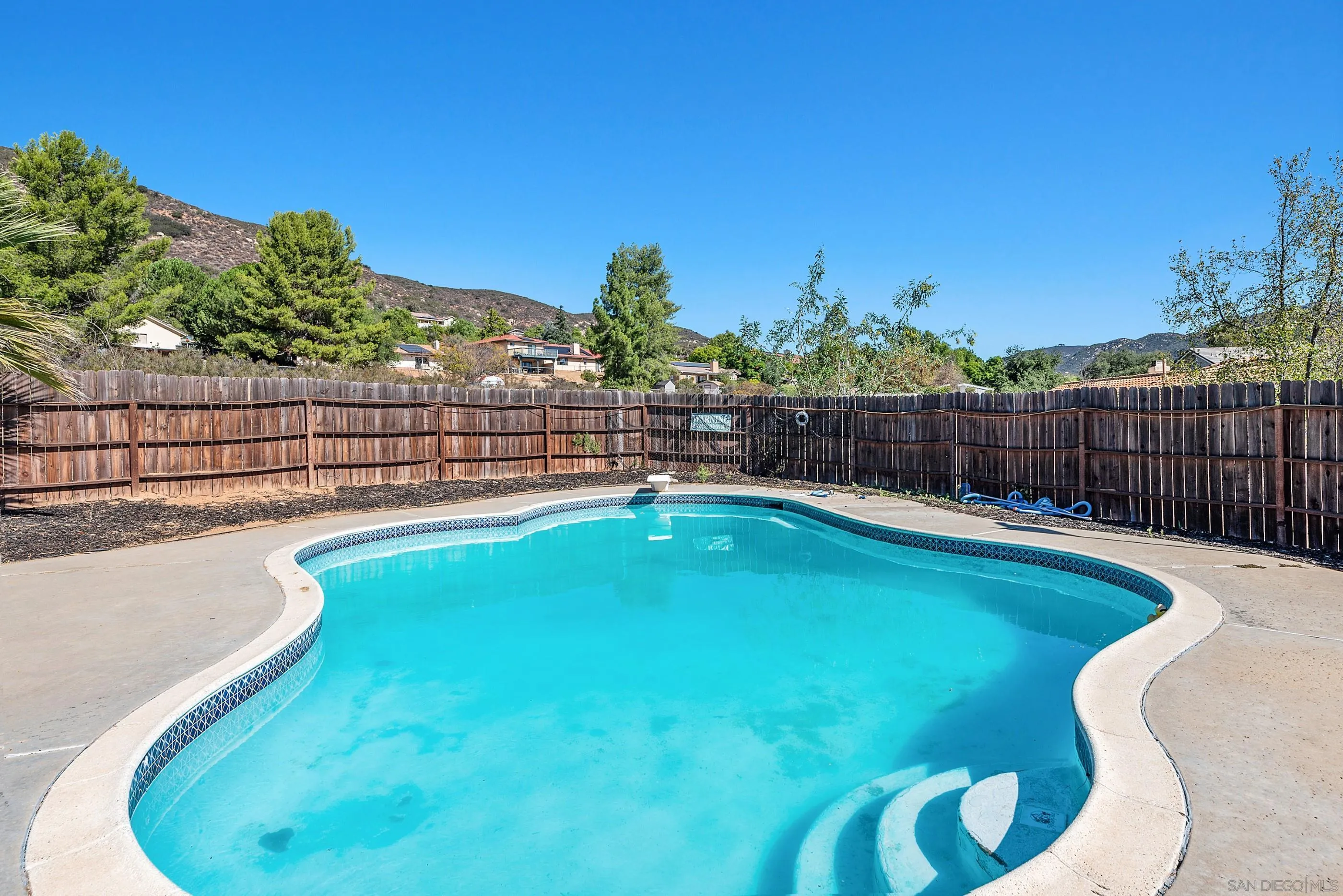 24252 Sargeant Road Ramona, CA 92065 - Photo 57 of 57 a view of a swimming pool with a lounge chair and a small yard