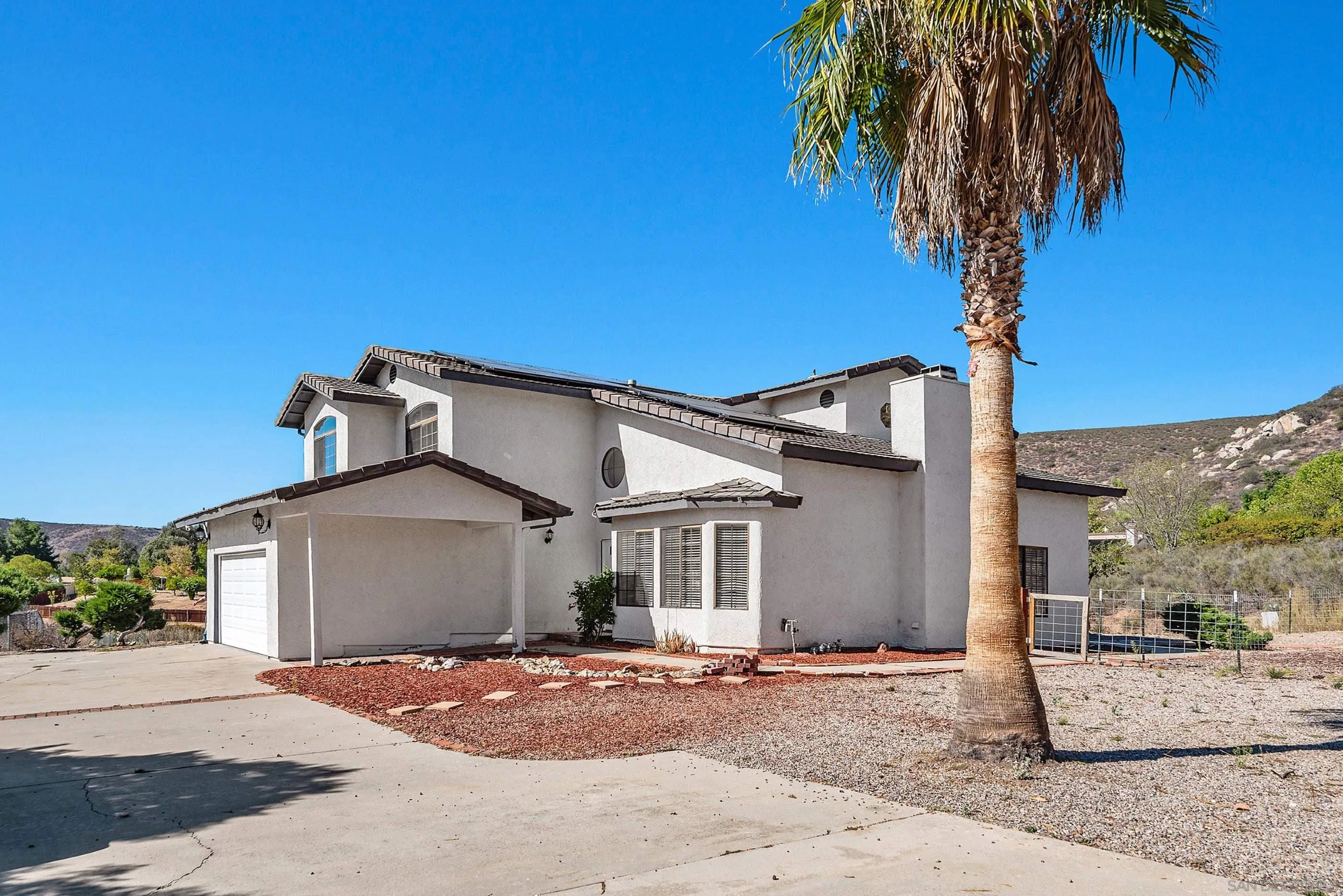 24252 Sargeant Road Ramona, CA 92065 - Photo 6 of 57 a front view of a house with a yard and garage