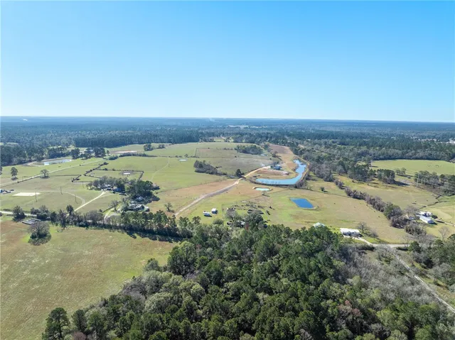 an aerial view of ocean and residential houses with outdoor space