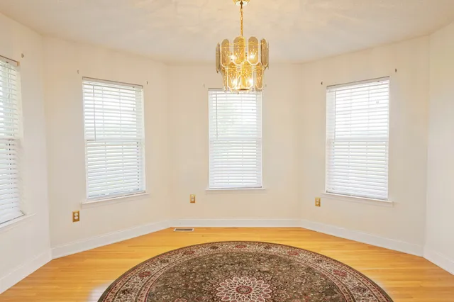 a view of an empty room with stairs and a hallway