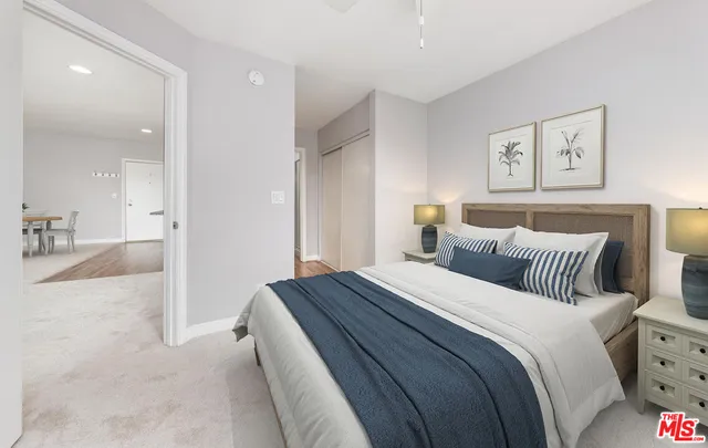 a bedroom with a bed and painting on the wall