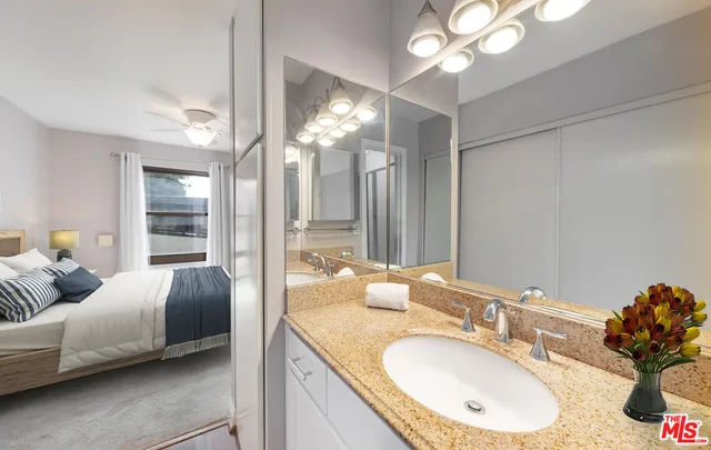 a en suite bathroom with a granite countertop double vanity and a mirror
