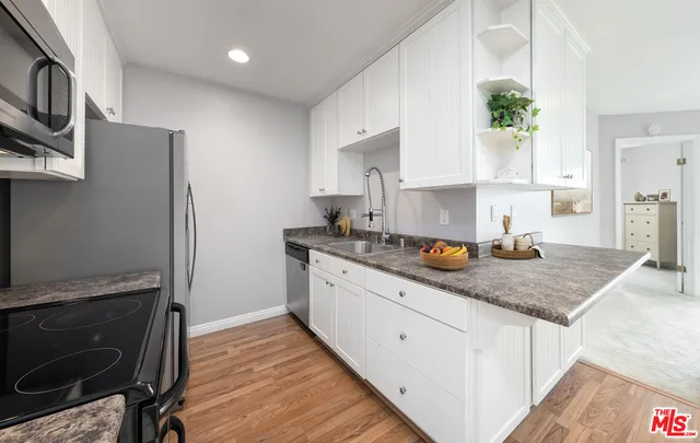 a kitchen with stainless steel appliances granite countertop a sink stove and cabinets