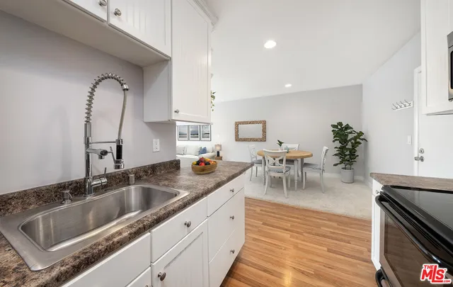a kitchen with stainless steel appliances granite countertop a sink refrigerator and cabinets