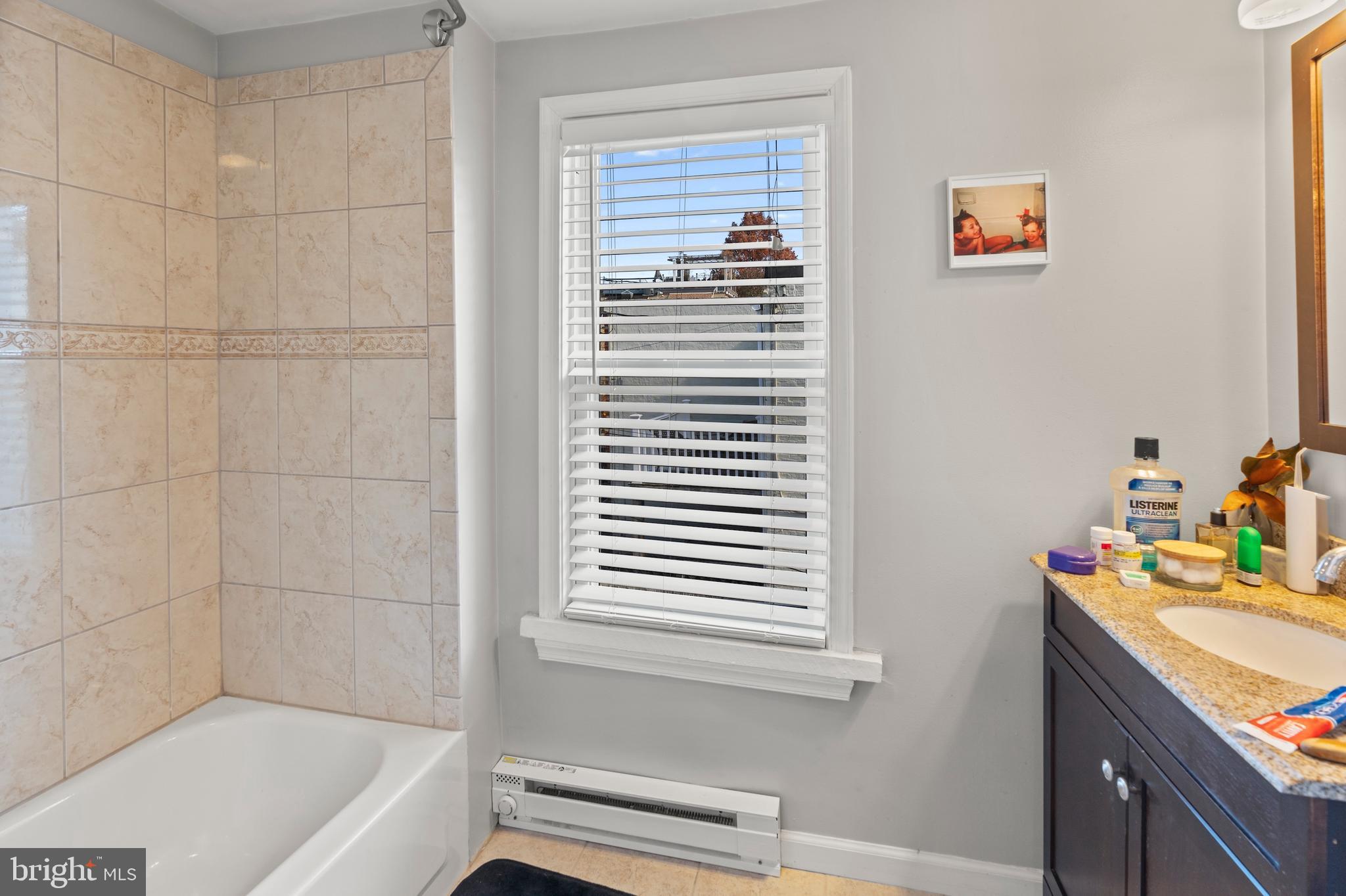 1043 Riverside Avenue Baltimore, MD 21230 - Photo 15 of 41 a bathroom with a tub a sink and a window