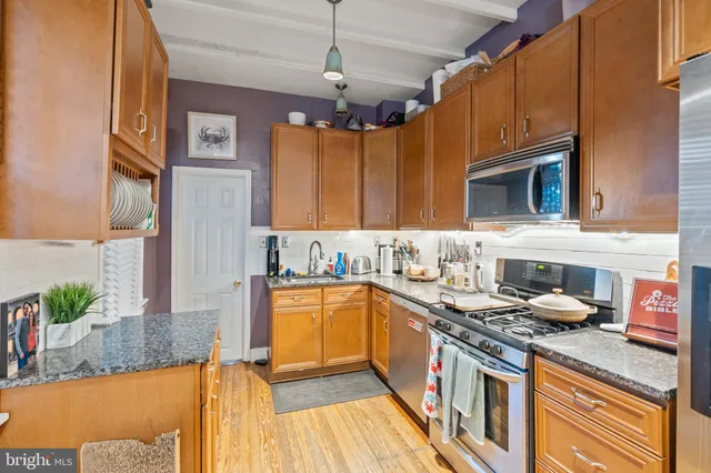 a kitchen with stainless steel appliances granite countertop a sink stove and cabinets