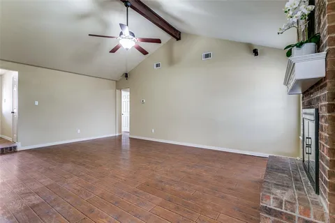 a living room with hard wood floors and a fireplace