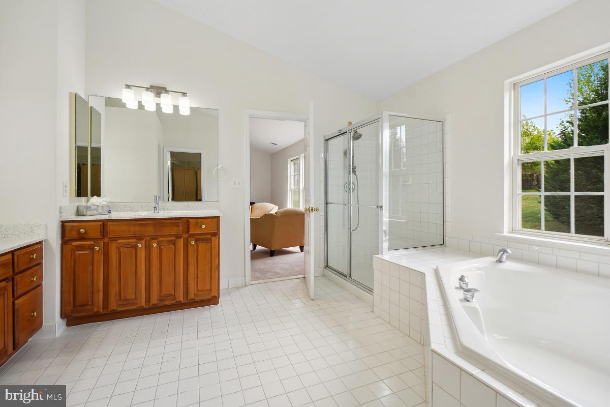 18521 Cornflower Road Boyds, MD 20841 - Photo 35 of 62 a spacious bathroom with a granite countertop sink mirror and a bathtub
