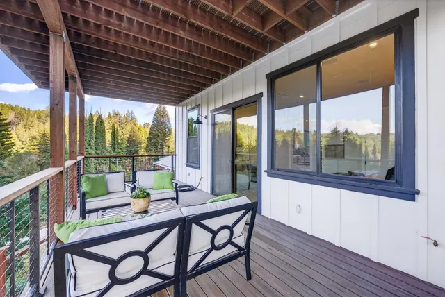 a kitchen with a stove a sink a counter top space and living room view