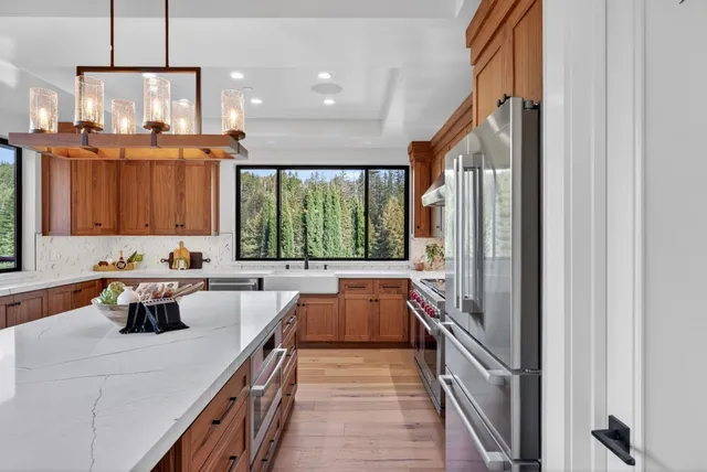 a bathroom with a granite countertop sink a toilet a large mirror and shower