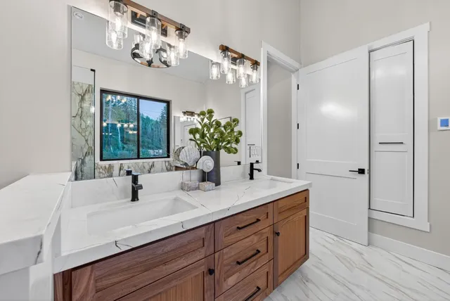 a spacious bathroom with a granite countertop sink and a mirror