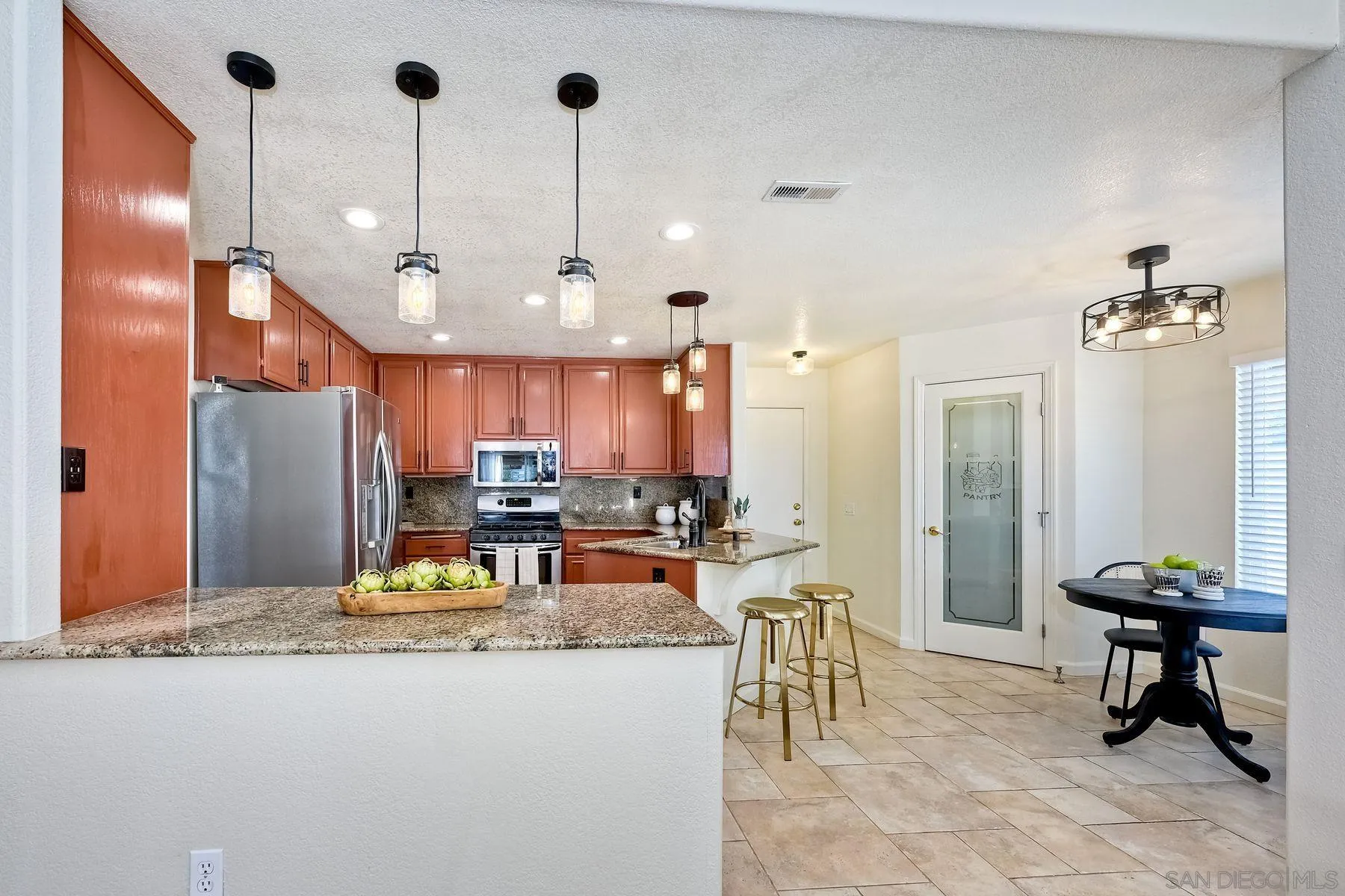 2859 Manzanita View Road Alpine, CA 91901 - Photo 22 of 66 a kitchen with stainless steel appliances kitchen island granite countertop a refrigerator a oven a sink and a dining table