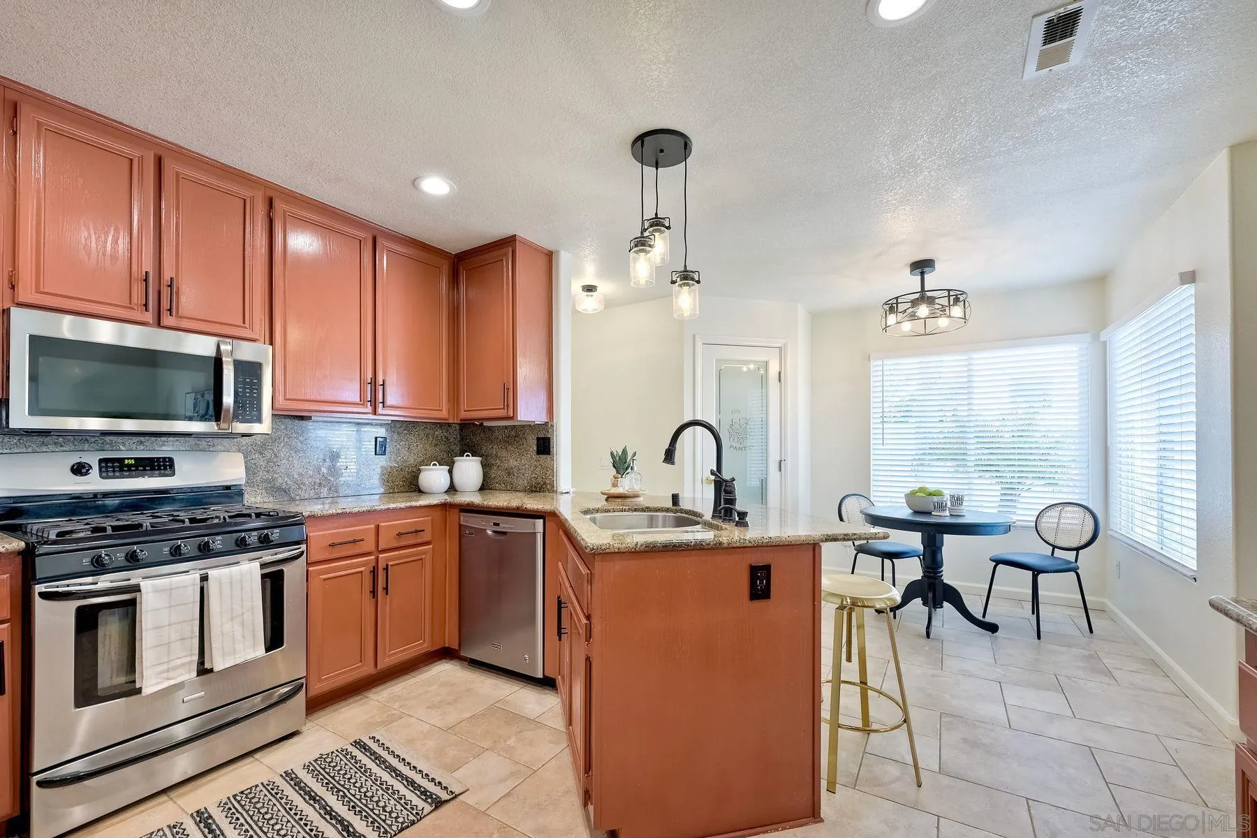 2859 Manzanita View Road Alpine, CA 91901 - Photo 26 of 66 a kitchen with stainless steel appliances a stove a sink a microwave and wooden cabinets