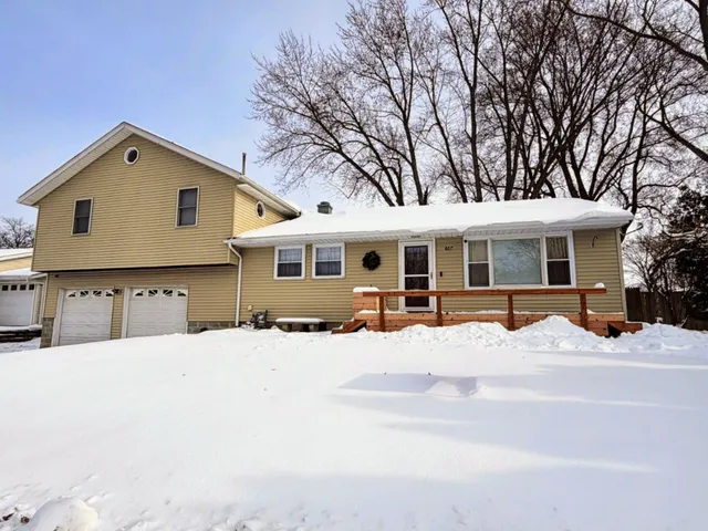 a front view of a house with a yard covered in snow