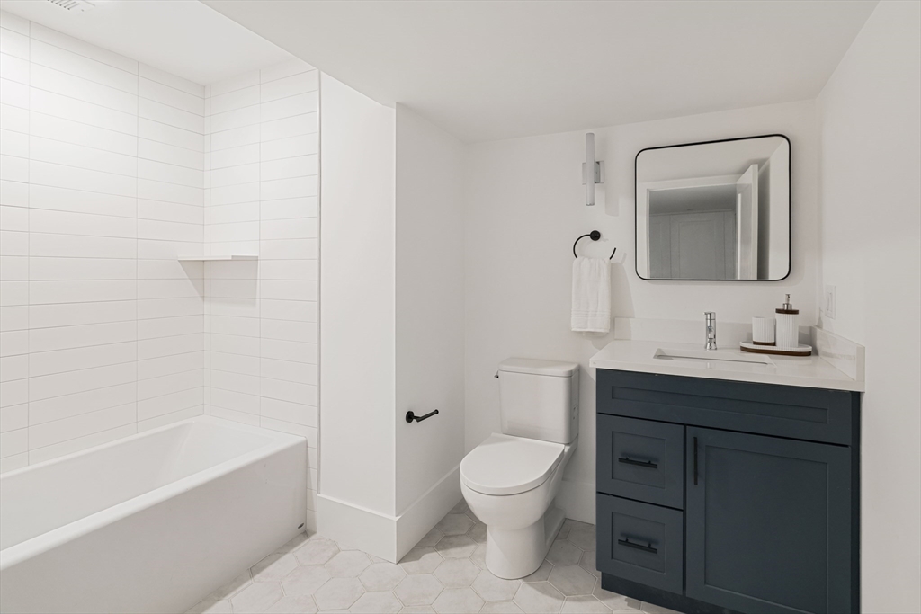 8 Poplar Road, Unit A Cambridge, MA 02138 - Photo 28 of 35 a bathroom with a toilet a sink a mirror a bathtub and vanity
