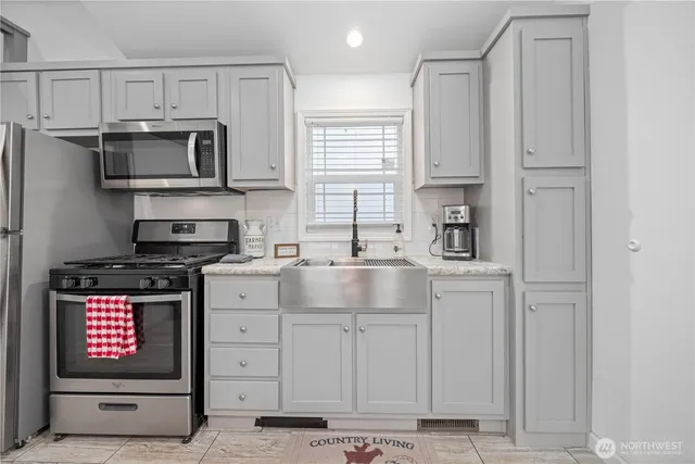 a kitchen with stainless steel appliances granite countertop a refrigerator sink and stove