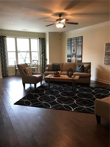 a living room with furniture flat screen tv and a large window