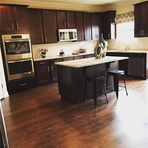 a kitchen with a sink a microwave a stove and cabinets