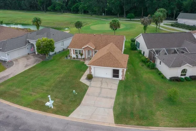 an aerial view of residential houses with outdoor space and trees