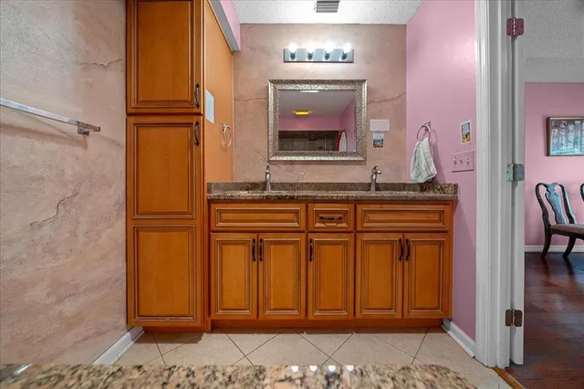 a bathroom with a granite countertop sink and a mirror