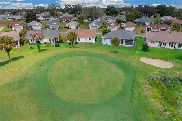 an aerial view of residential houses with outdoor space and trees