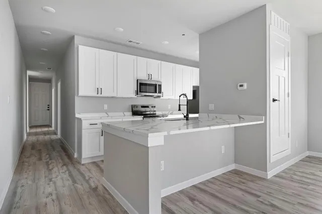 a kitchen with a sink cabinets and wooden floor