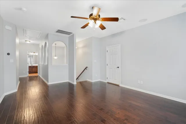 an empty room with a window and a ceiling fan