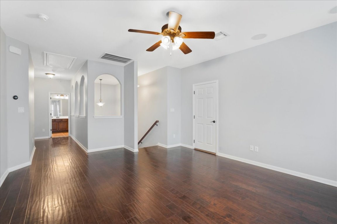 1813 Tall Chief Leander, TX 78641 - Photo 21 of 26 Unfurnished living room with baseboards, attic access, ceiling fan, and wood finished floors