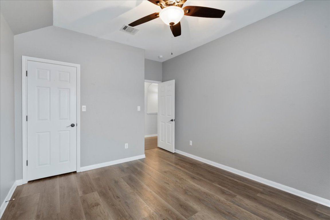 1813 Tall Chief Leander, TX 78641 - Photo 24 of 26 Unfurnished bedroom featuring a ceiling fan, baseboards, visible vents, and wood finished floors