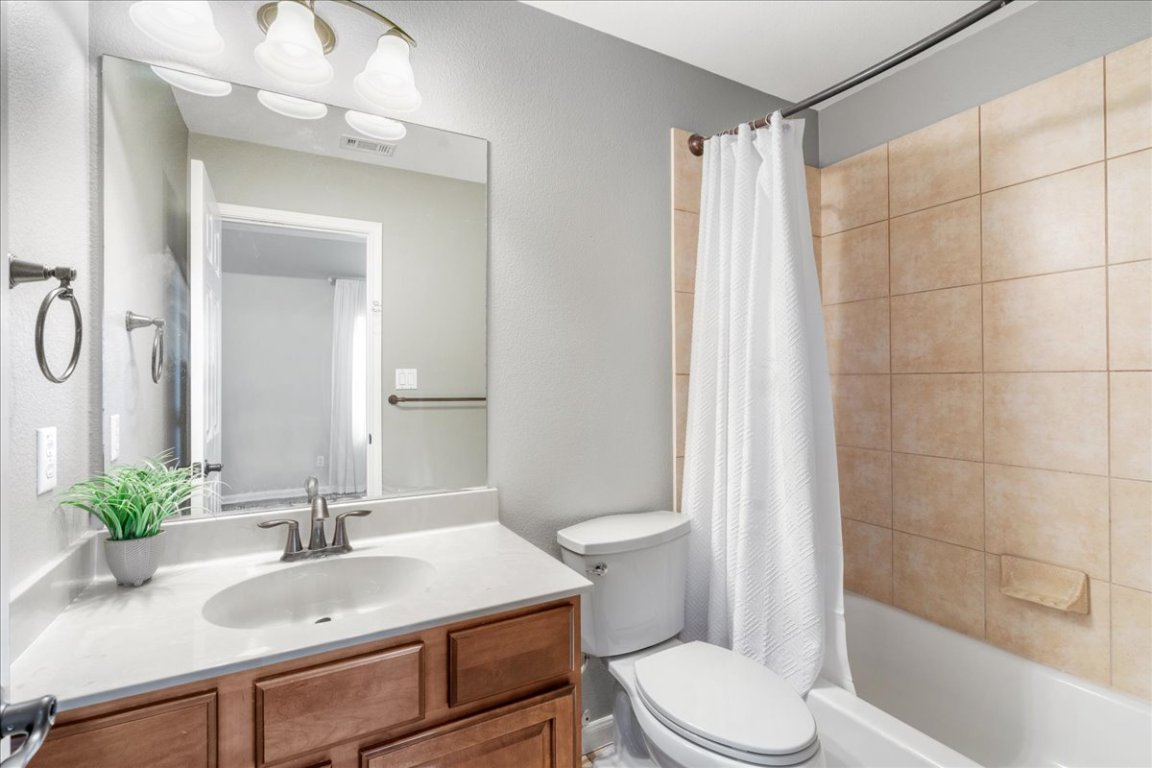 1813 Tall Chief Leander, TX 78641 - Photo 25 of 26 Full bath featuring vanity, shower / bath combo with shower curtain, toilet, and visible vents
