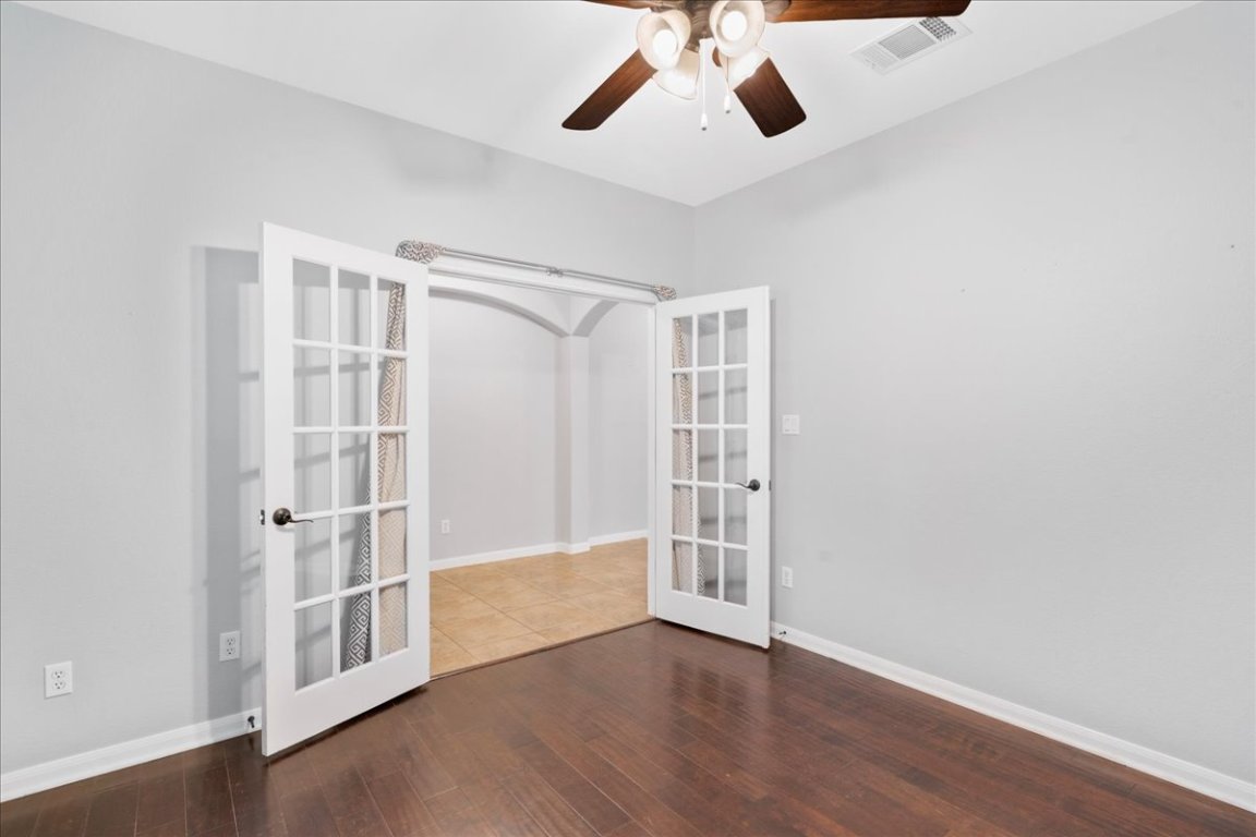 1813 Tall Chief Leander, TX 78641 - Photo 9 of 26 Spare room with ceiling fan, french doors, baseboards, wood finished floors, and visible vents